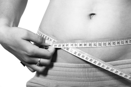 腹囲をメジャーで計測している女性の画像