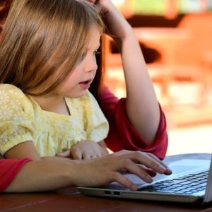 子どもが母親とパソコンに向かう画像